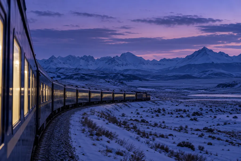 Tren de pasajeros avanzando por una estepa nevada hacia las montañas (imagen generada con AI)