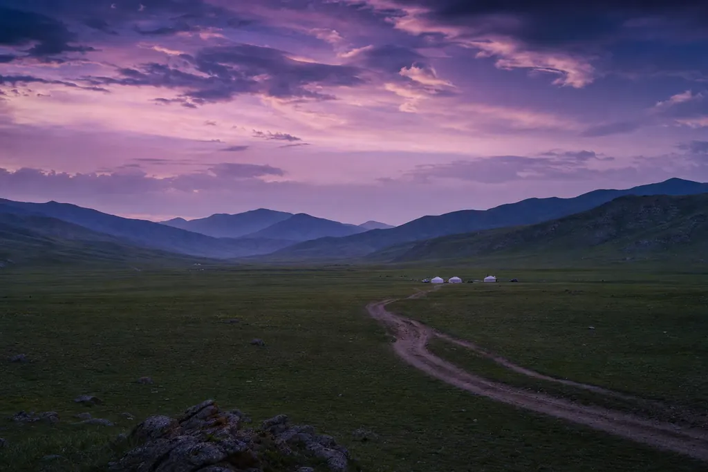 Estepa de Mongolia al anochecer con tiendas de fieltro en el valle (imagen generada con AI)